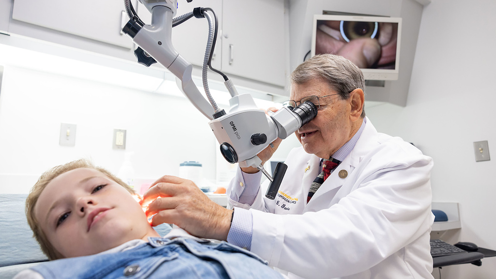 Bruce J. Gantz, MD, examines a pediatric patient